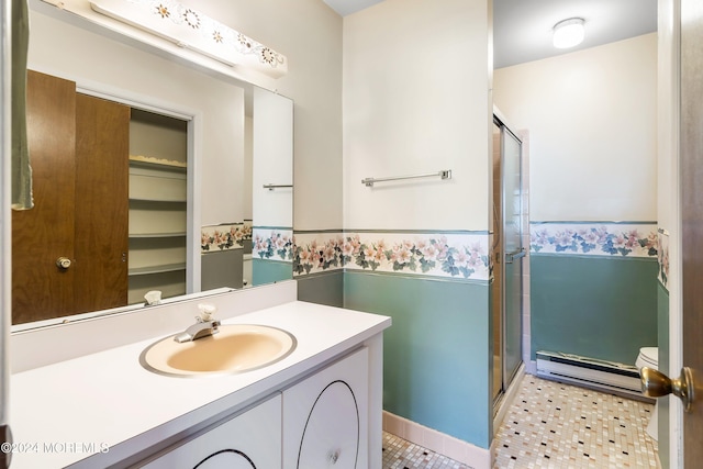 bathroom with walk in shower, vanity, and a baseboard heating unit