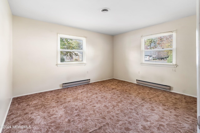 carpeted empty room with a baseboard heating unit