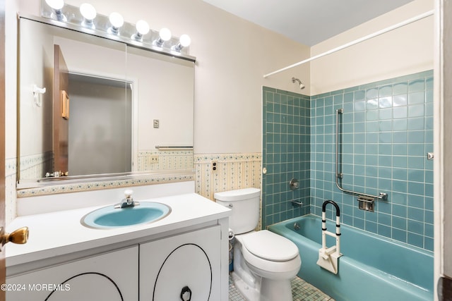 full bathroom featuring toilet, tiled shower / bath combo, vanity, and tile patterned floors