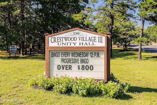 community sign featuring a yard