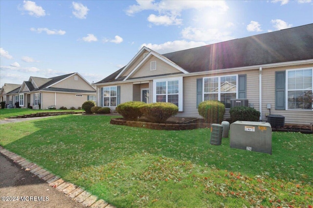 single story home with central AC unit and a front yard