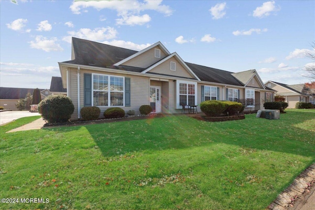 view of front of house with central AC unit and a front yard