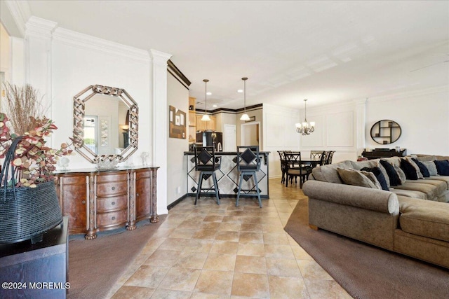 living room featuring ornate columns, a notable chandelier, and ornamental molding