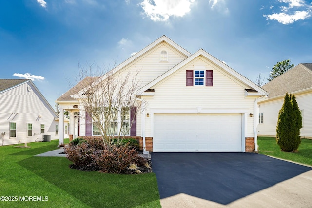 traditional-style house featuring brick siding, central air condition unit, a front yard, a garage, and driveway