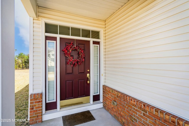 doorway to property featuring brick siding