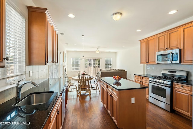 kitchen featuring a sink, dark wood-style flooring, backsplash, and stainless steel appliances