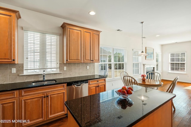 kitchen featuring a sink, brown cabinets, decorative backsplash, and stainless steel dishwasher