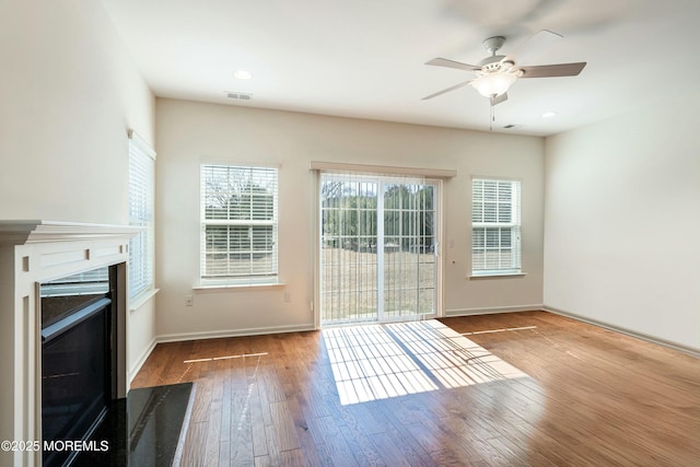 entryway featuring a fireplace with flush hearth, baseboards, and wood-type flooring