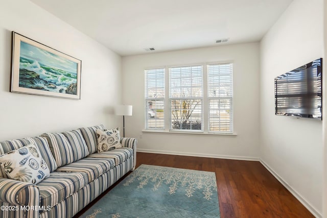 living room with visible vents, baseboards, and wood finished floors