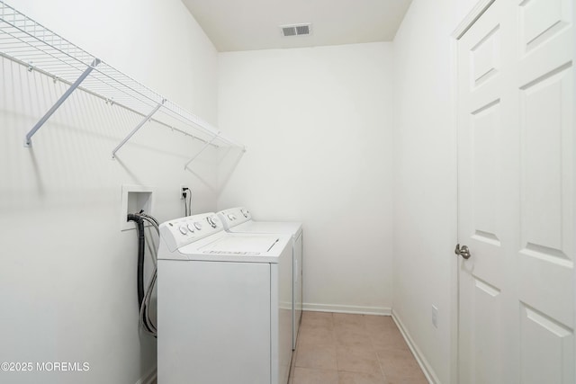 laundry area featuring visible vents, washer and dryer, light tile patterned floors, baseboards, and laundry area