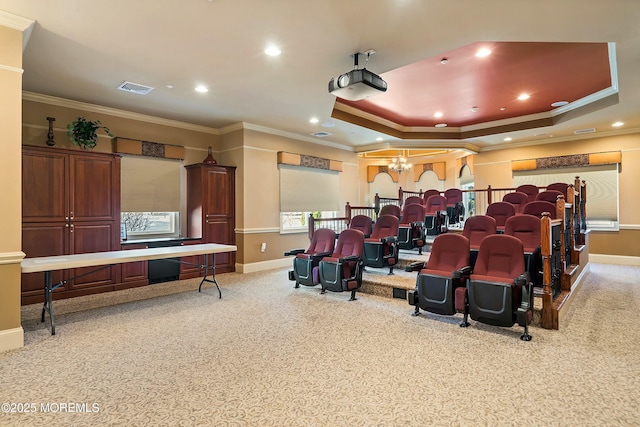 carpeted home theater featuring recessed lighting, baseboards, a raised ceiling, and ornamental molding