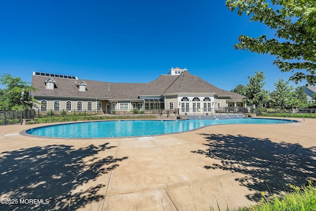 pool with a patio area and fence