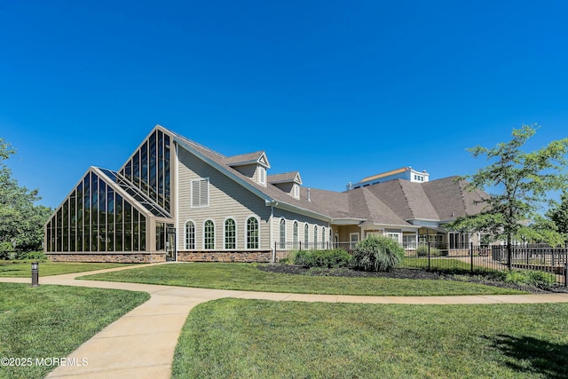 exterior space with a yard, stone siding, and fence