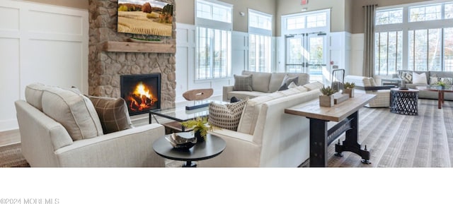 living room featuring a fireplace, a healthy amount of sunlight, and a high ceiling