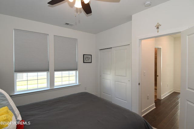 unfurnished bedroom with ceiling fan, a closet, and dark hardwood / wood-style flooring