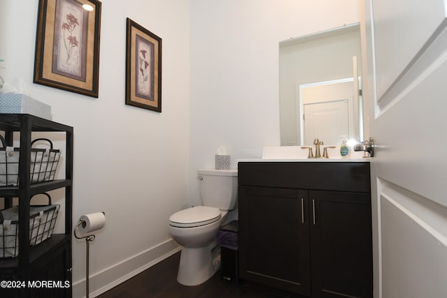 bathroom featuring vanity, hardwood / wood-style flooring, and toilet