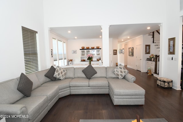 living room featuring hardwood / wood-style floors, decorative columns, a high ceiling, and ornamental molding