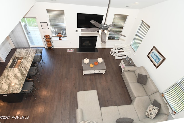 living room with hardwood / wood-style floors, ceiling fan, and a towering ceiling