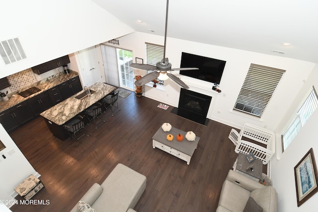 living room featuring high vaulted ceiling, dark hardwood / wood-style floors, ceiling fan, and sink