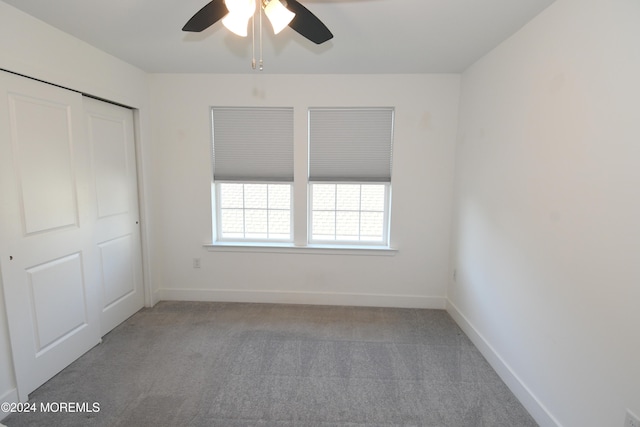 unfurnished bedroom featuring a closet, light carpet, and ceiling fan