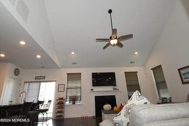 living room with ceiling fan, wood-type flooring, and high vaulted ceiling