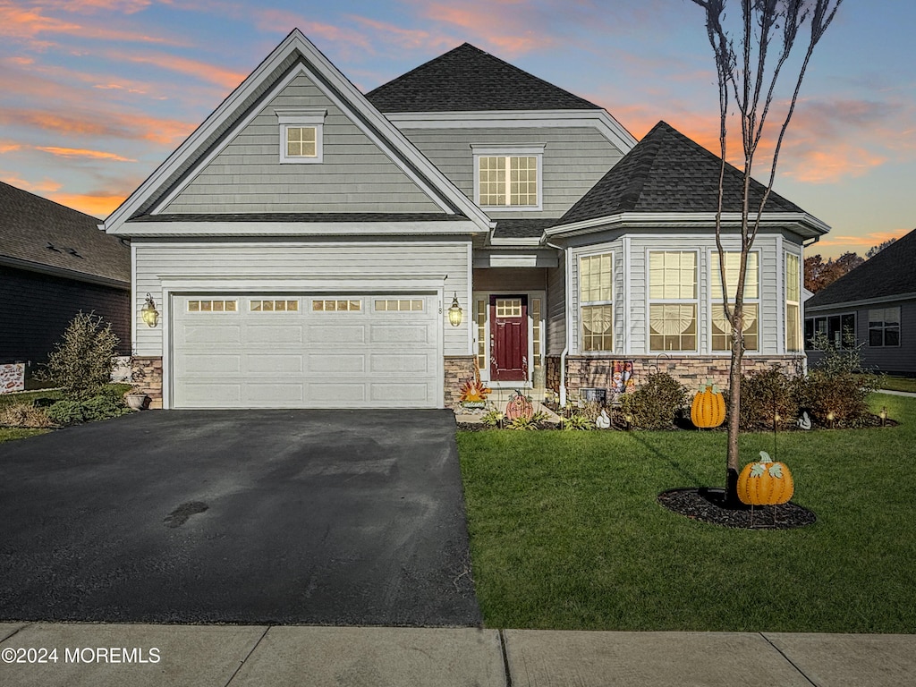 craftsman inspired home featuring a garage and a yard