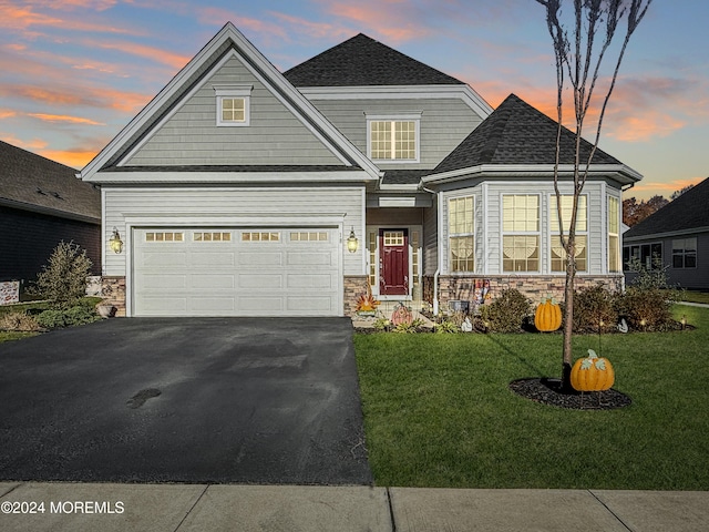 craftsman inspired home featuring a garage and a yard