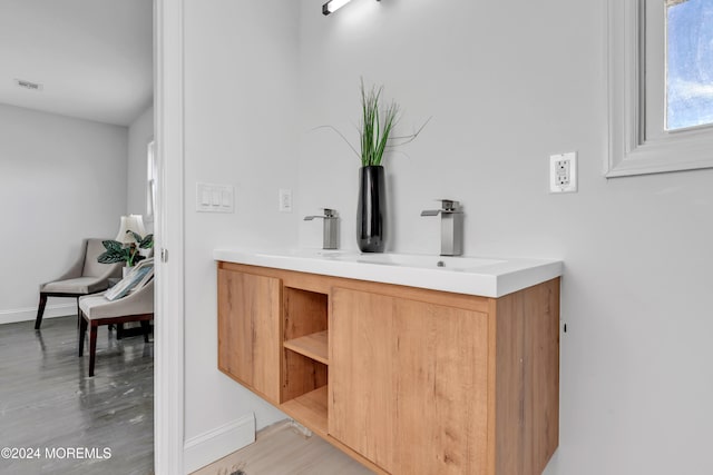 bar featuring light hardwood / wood-style flooring and sink