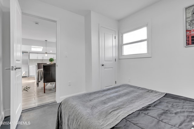 bedroom featuring hardwood / wood-style floors and fridge