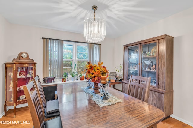 dining space featuring light hardwood / wood-style flooring and a chandelier