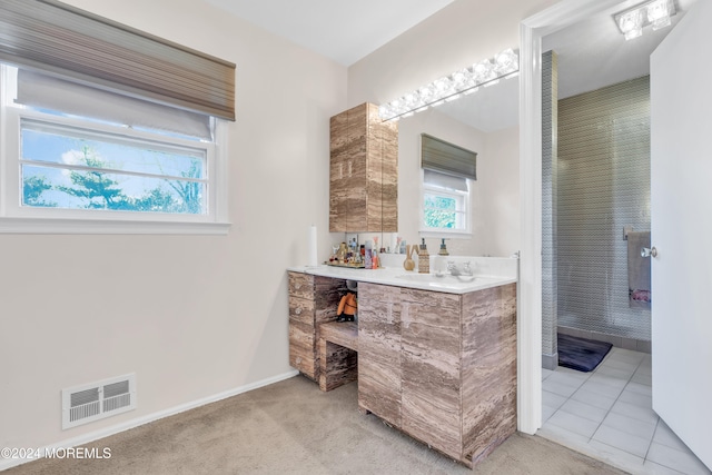 bathroom featuring vanity, tile patterned flooring, and a healthy amount of sunlight