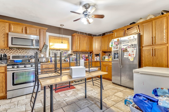 kitchen featuring decorative light fixtures, ceiling fan, decorative backsplash, and stainless steel appliances