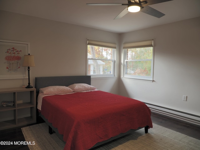 bedroom with hardwood / wood-style flooring, baseboard heating, and ceiling fan