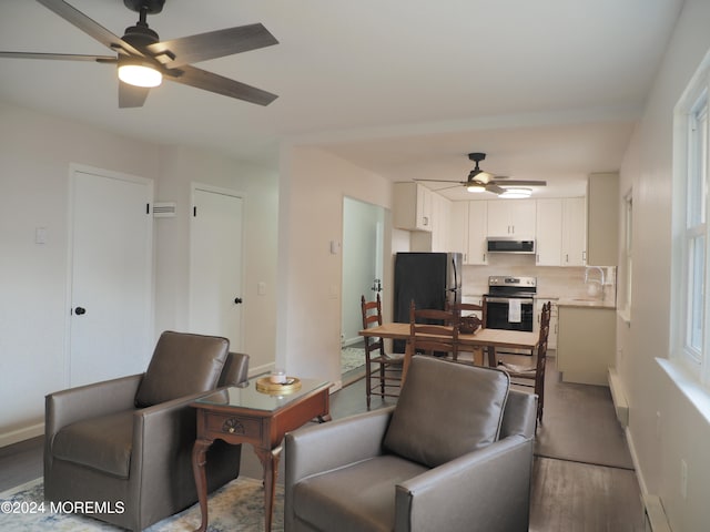 living room with hardwood / wood-style floors, ceiling fan, and sink