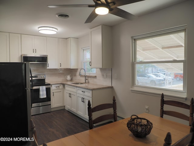 kitchen featuring stainless steel appliances, white cabinetry, sink, backsplash, and dark wood-type flooring