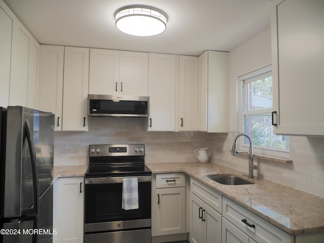 kitchen with white cabinetry, appliances with stainless steel finishes, sink, and backsplash