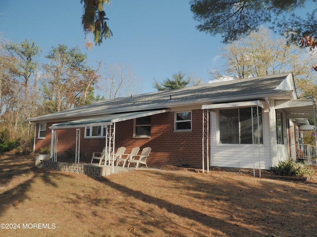 back of property featuring a lawn