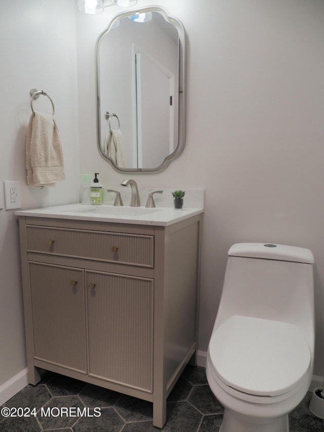 bathroom featuring toilet, vanity, and tile patterned flooring