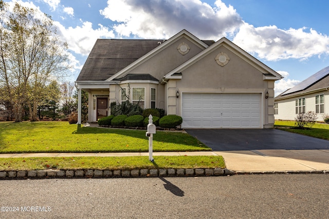 view of front of home with a garage and a front lawn