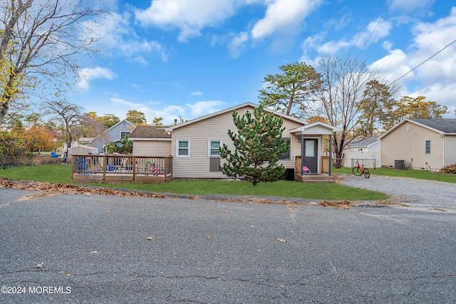 bungalow-style house with cooling unit, a front yard, and a deck