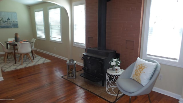 living room with dark hardwood / wood-style flooring and a wood stove