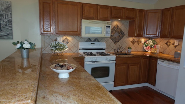 kitchen with decorative backsplash, sink, dark hardwood / wood-style floors, and white appliances