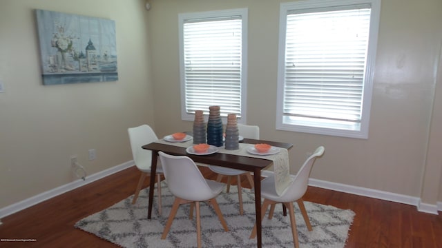 dining space with plenty of natural light and dark hardwood / wood-style flooring