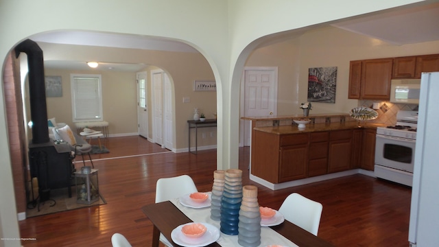 kitchen featuring decorative backsplash, dark hardwood / wood-style floors, and white appliances