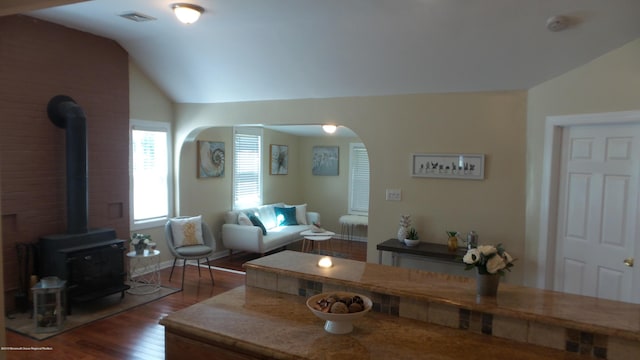 living room with lofted ceiling, dark hardwood / wood-style floors, and a wood stove