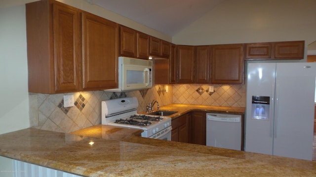 kitchen with tasteful backsplash, white appliances, lofted ceiling, light stone counters, and sink