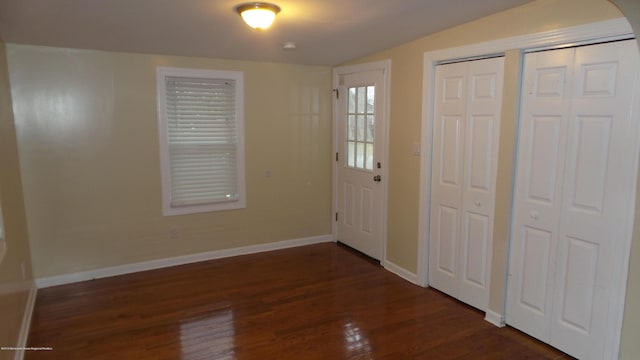 entryway with vaulted ceiling and dark hardwood / wood-style flooring