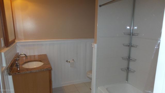 full bathroom featuring washtub / shower combination, tile patterned floors, toilet, and vanity