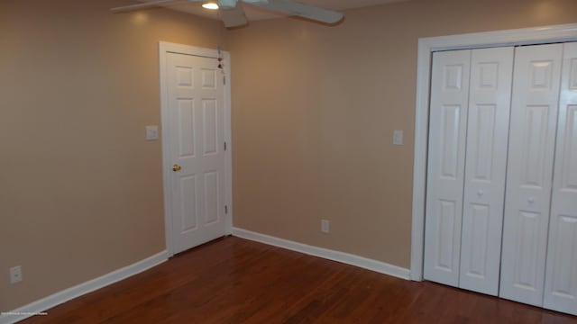 unfurnished bedroom featuring ceiling fan, dark wood-type flooring, and a closet