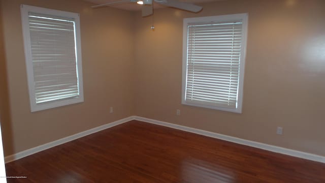 unfurnished room featuring dark wood-type flooring and ceiling fan